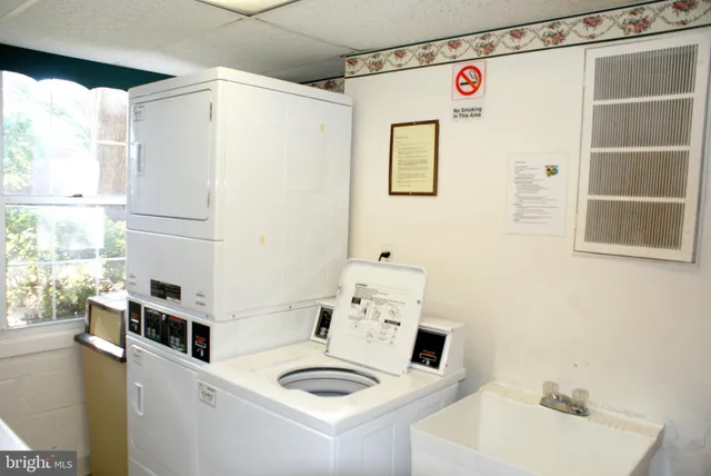 a bathroom with a sink a refrigerator and a window