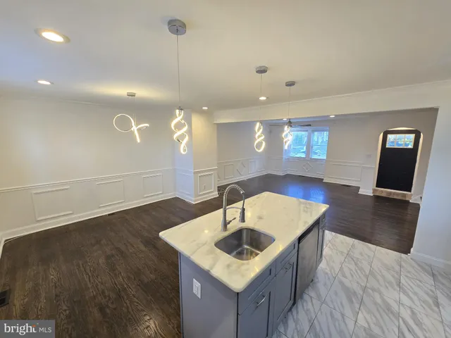 a kitchen with a sink a counter space and wooden floor