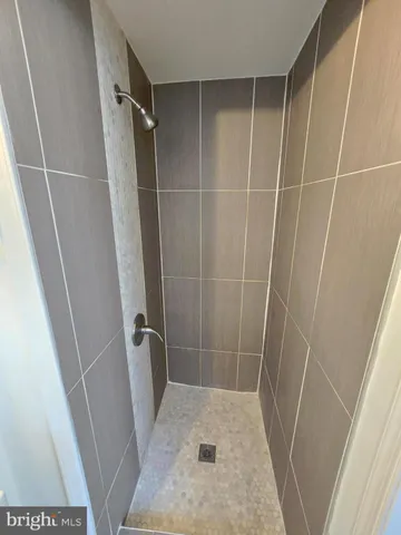 a bathroom with a sink a toilet a shower and a window