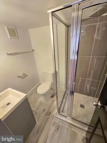 a bathroom with a sink a toilet a mirror and shower