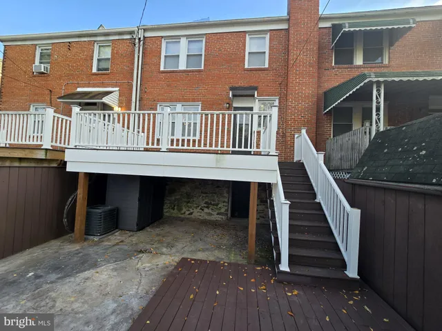 a view of a house with wooden deck front of house
