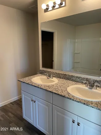 a bathroom with a granite countertop sink and a wooden vanity