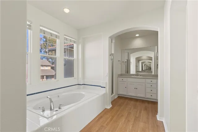 a bathroom with a tub sink and mirror
