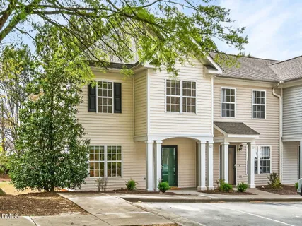 a front view of a house with a garden and tree