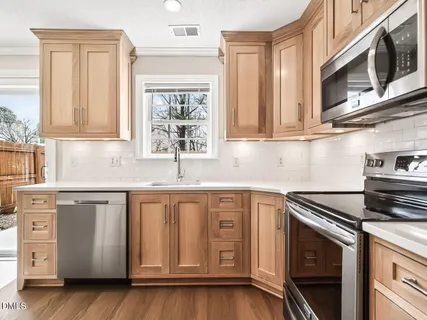 a kitchen with stainless steel appliances granite countertop a sink a stove and a microwave