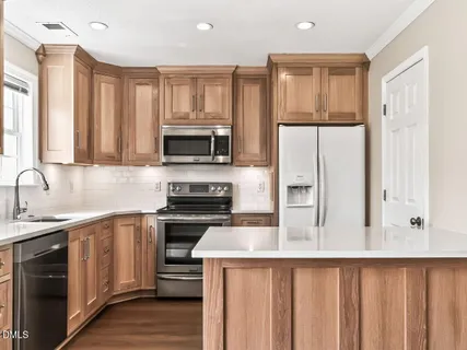 a kitchen with a sink a stove a refrigerator and cabinets