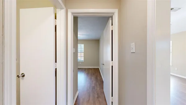 a view of a hallway with wooden floor