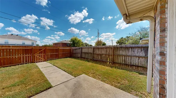 a view of a backyard with wooden fence