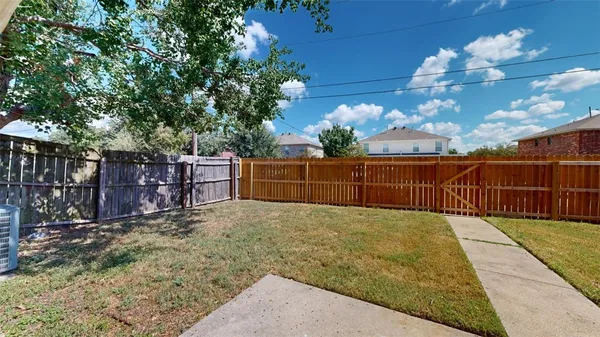 a view of backyard with wooden fence