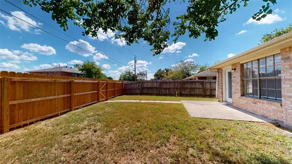 a front view of a house with a garden and trees
