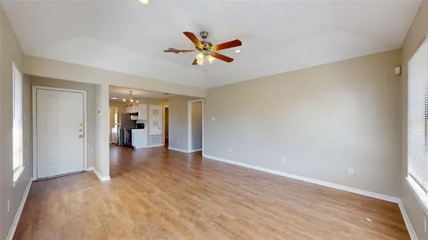 a view of an empty room with closet and a window