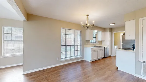 a large kitchen with a window and stainless steel appliances