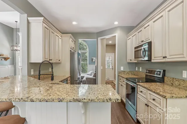 a kitchen with stainless steel appliances granite countertop a stove a sink and a microwave