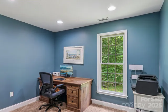 a view of a workspace with furniture and a window