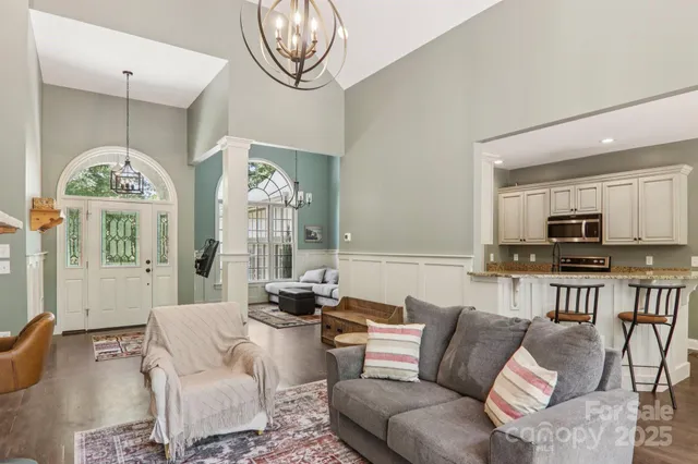 a living room with furniture a large window and a dining table
