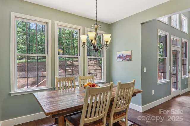 a dining room with furniture large windows and a chandelier