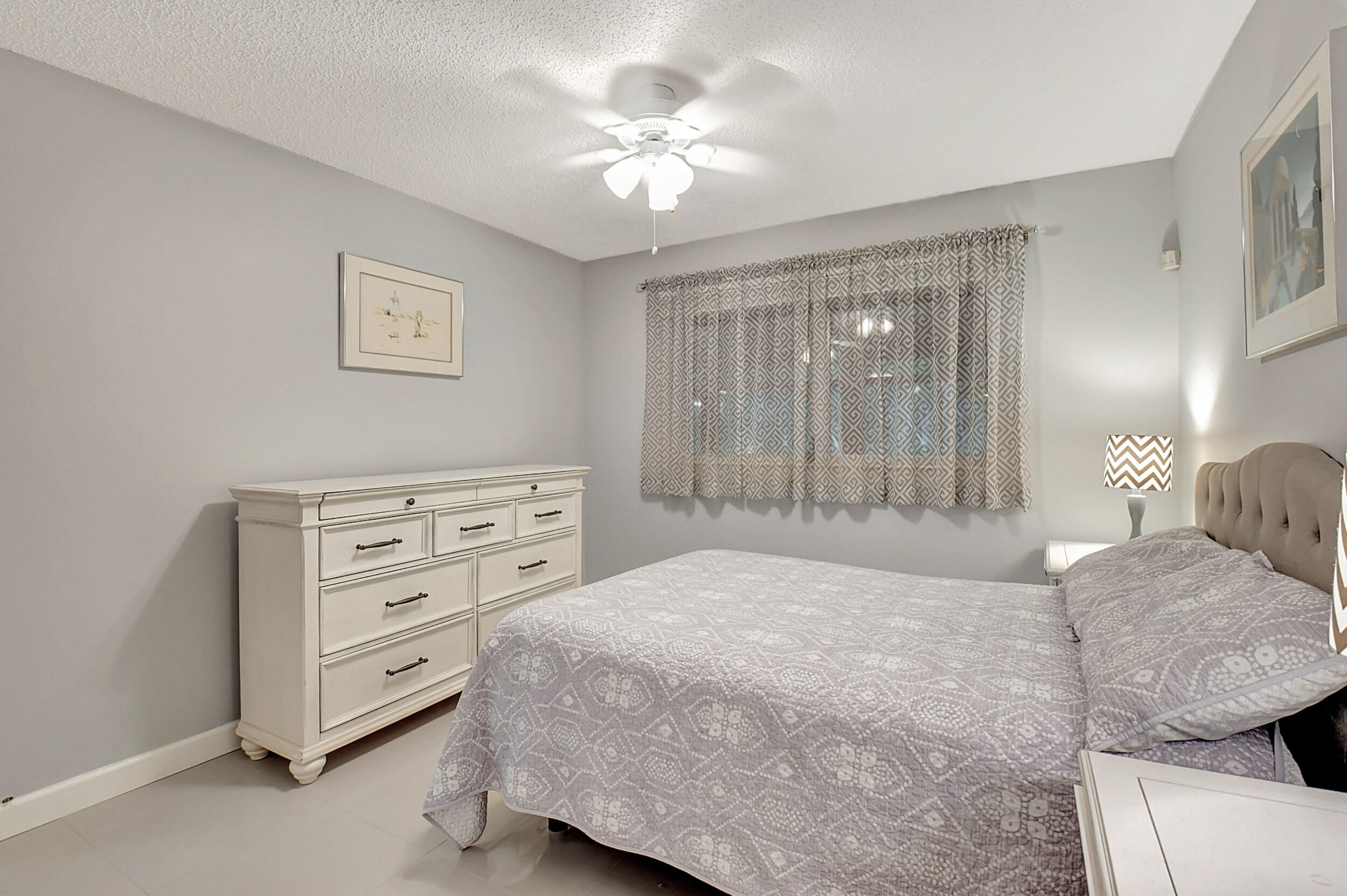 14520 Lucy Drive Delray Beach, FL 33484 - Photo 20 of 63 a bedroom with a bed and a chandelier