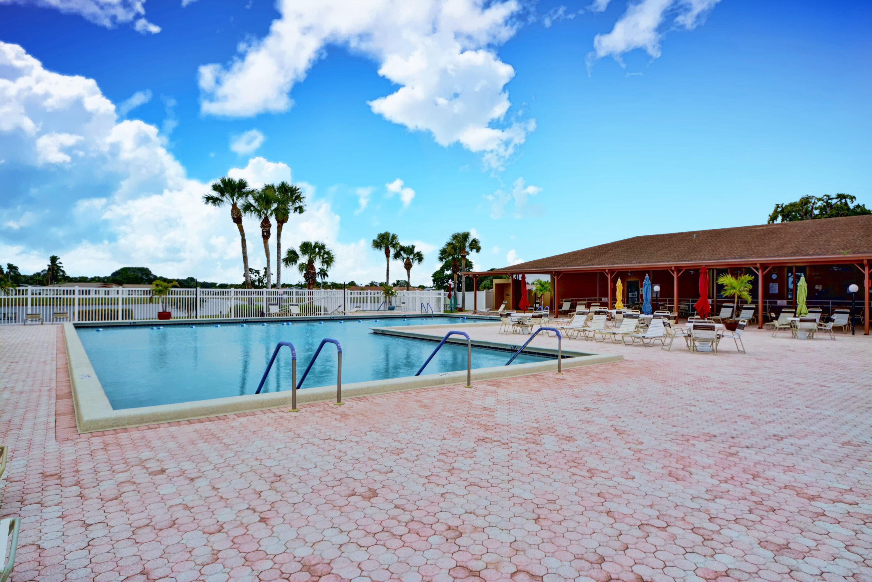 14520 Lucy Drive Delray Beach, FL 33484 - Photo 47 of 63 a view of a swimming pool with lawn chairs under an umbrella