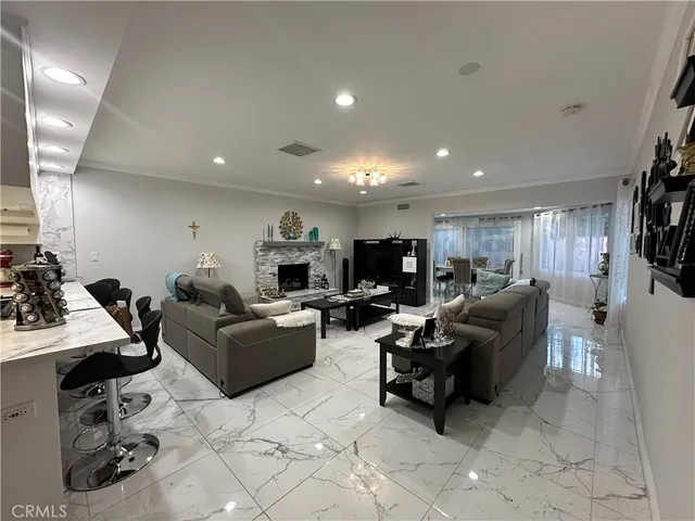 a living room with furniture a computer on the desk and a flat screen tv