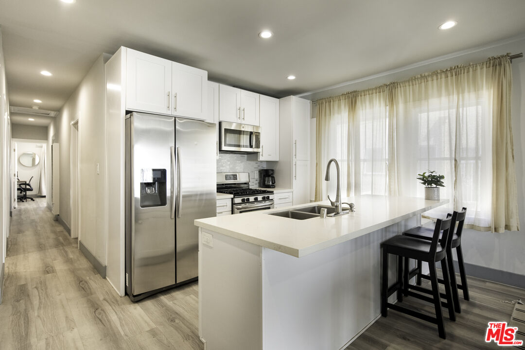 1559 1/2 South Harvard Boulevard Los Angeles, CA 90006 - Photo 1 of 16 a kitchen with kitchen island a sink stove and refrigerator