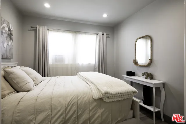 a bedroom with a bed and a painting on the wall