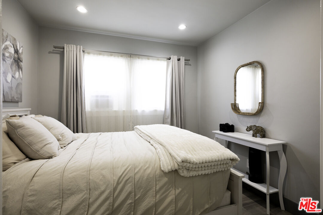 1559 1/2 South Harvard Boulevard Los Angeles, CA 90006 - Photo 11 of 16 a bedroom with a bed a dresser and a mirror