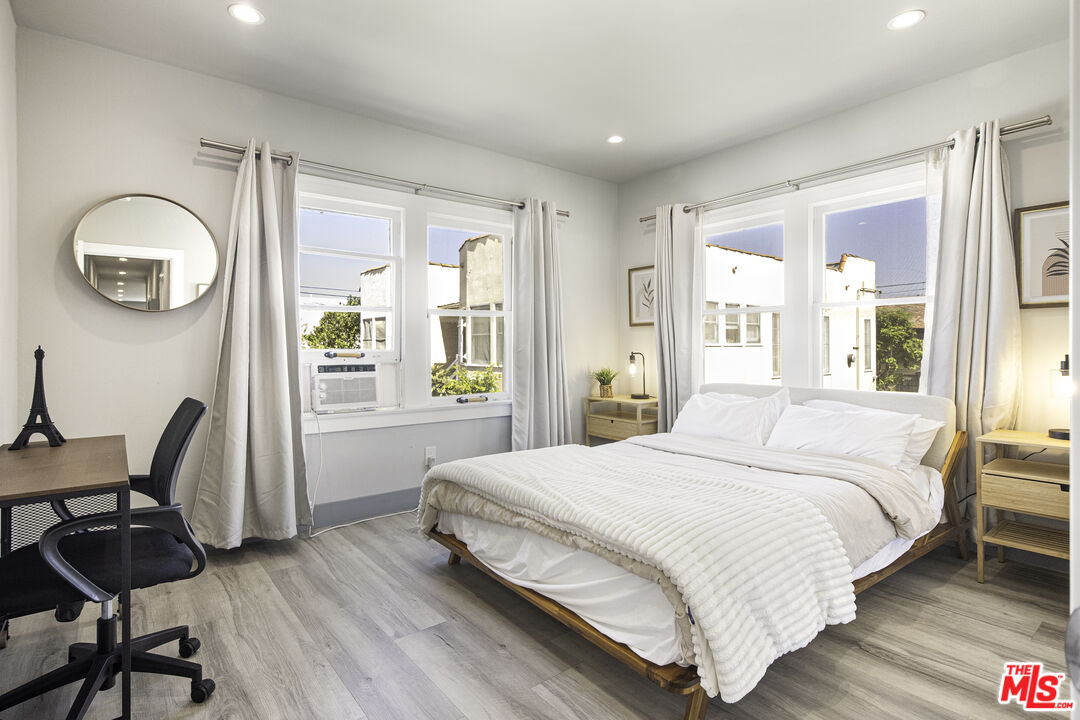 1559 1/2 South Harvard Boulevard Los Angeles, CA 90006 - Photo 8 of 16 a bedroom with a bed a chair and a large window