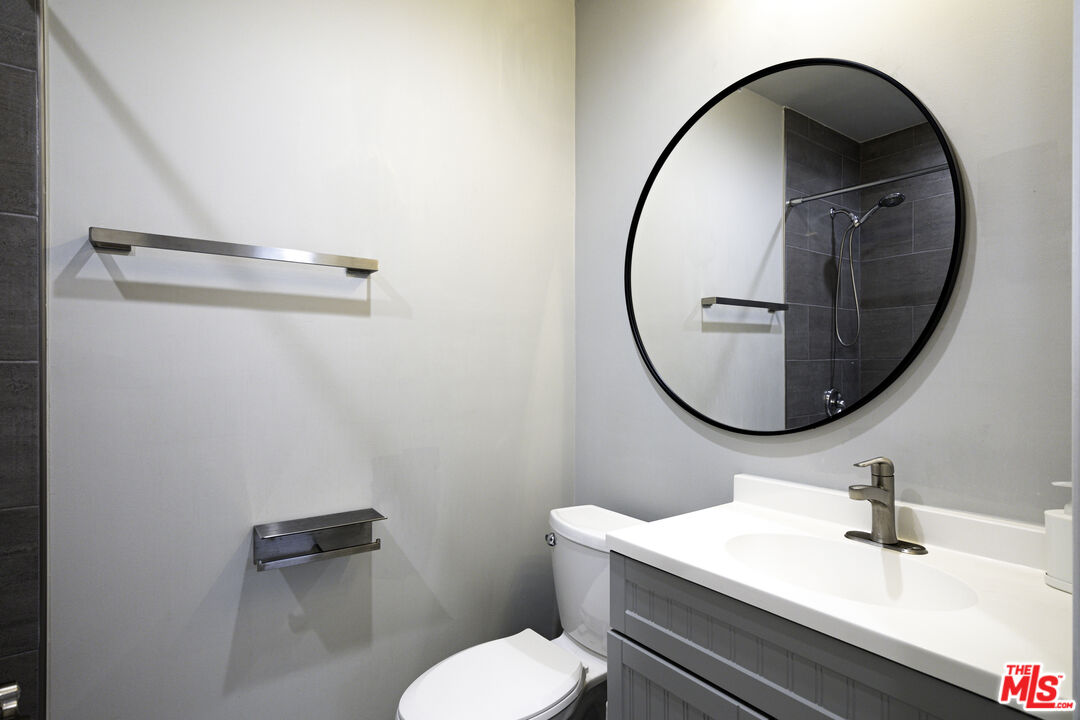 1559 1/2 South Harvard Boulevard Los Angeles, CA 90006 - Photo 10 of 16 a bathroom with a sink a mirror and a toilet
