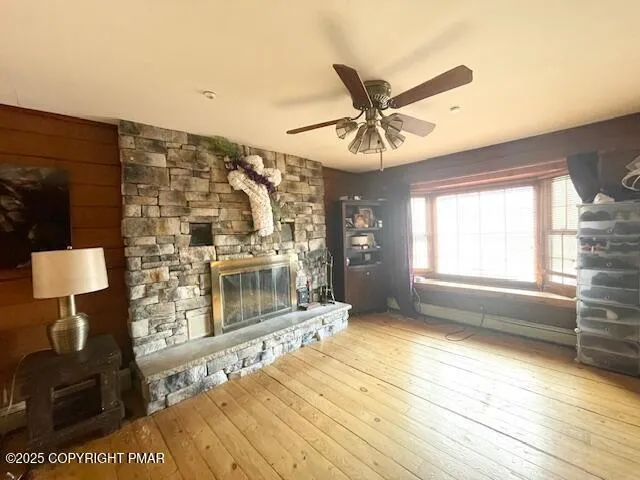 a view of a livingroom with wooden floor and a ceiling fan