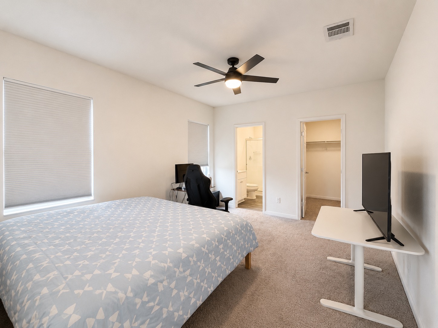 160 Light Timber Road Maxwell, TX 78656 - Photo 5 of 11 A well-lit bedroom features plush carpeting, a ceiling fan, and convenient access to an en-suite bathroom and closet.