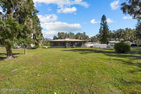 a view of a white house with a yard and sitting area