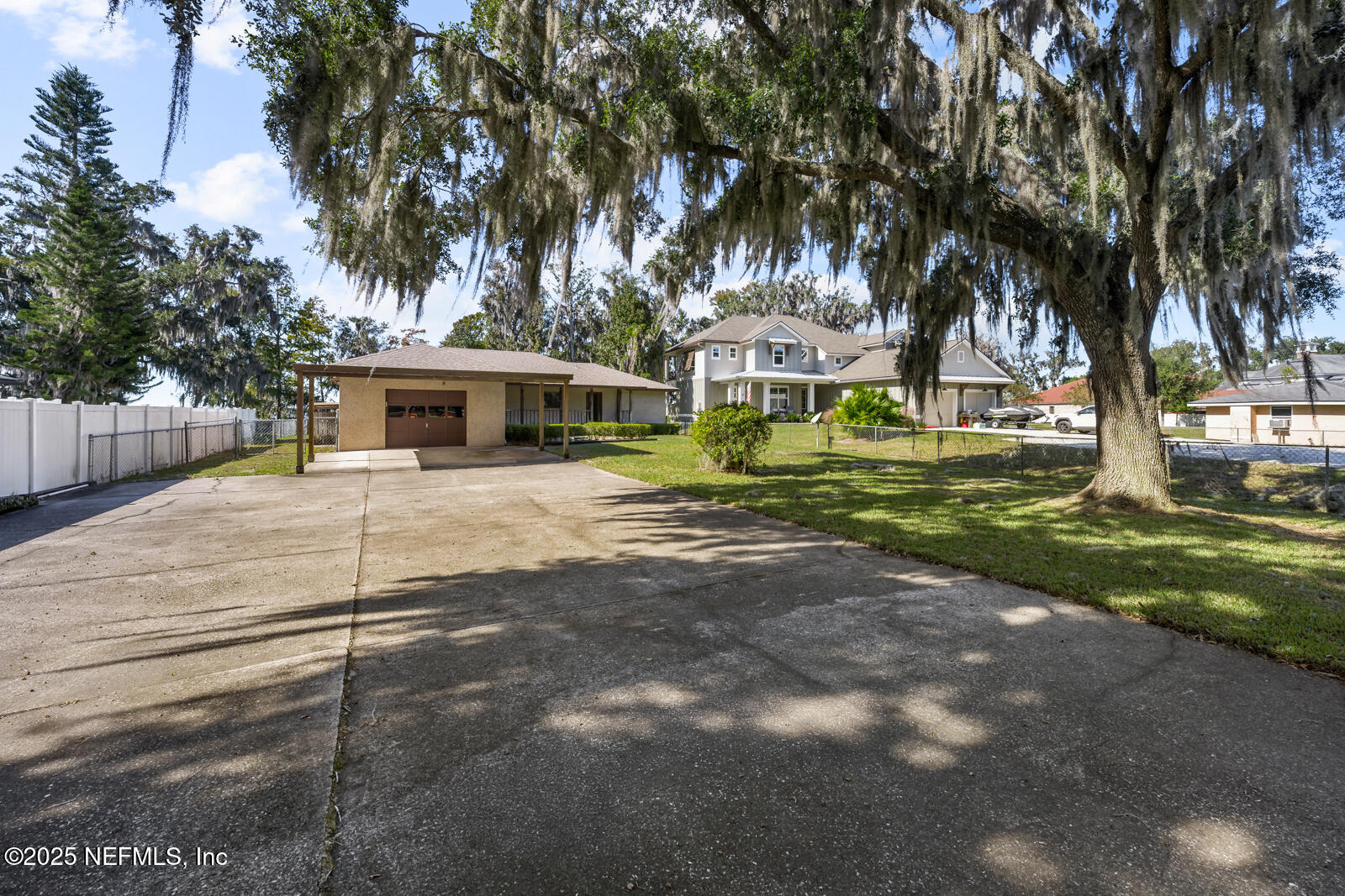6365 Jack Wright Island Road St. Augustine, FL 32092 - Photo 45 of 53 a view of a white house with a yard and sitting area