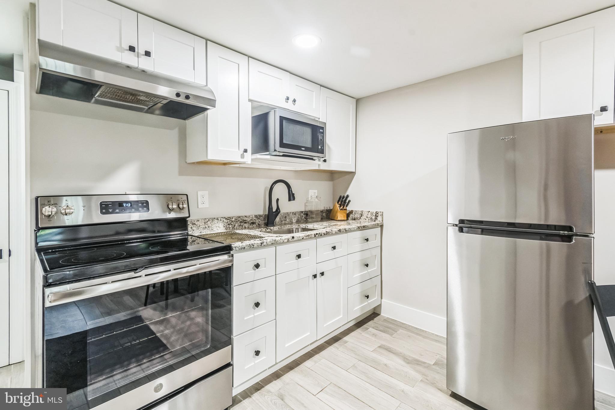 a kitchen with appliances a refrigerator and cabinets