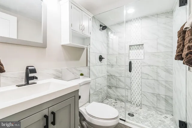 a bathroom with a sink a toilet and shower