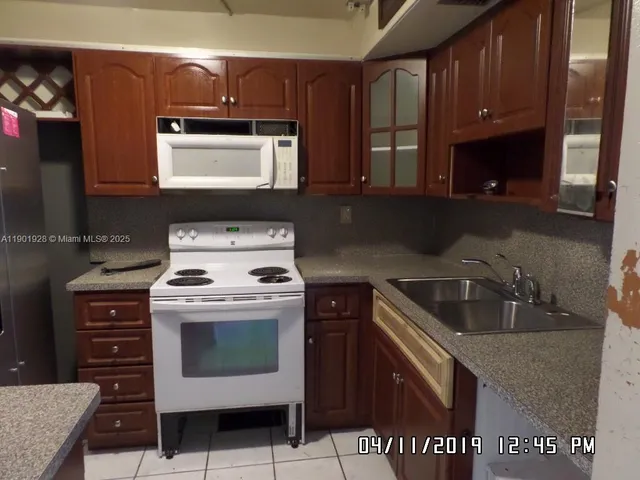 a kitchen with granite countertop a sink stove and cabinets