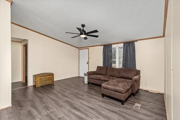 a living room with furniture and a ceiling fan