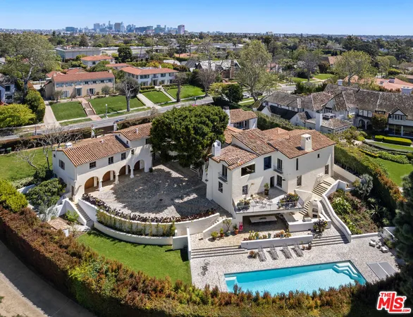 an aerial view of a house with a garden and lake view