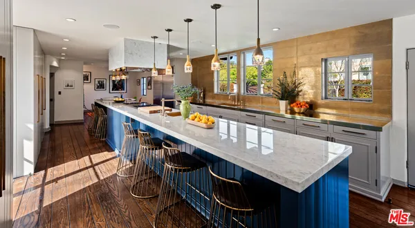a kitchen with stainless steel appliances granite countertop a sink a stove and a wooden floors