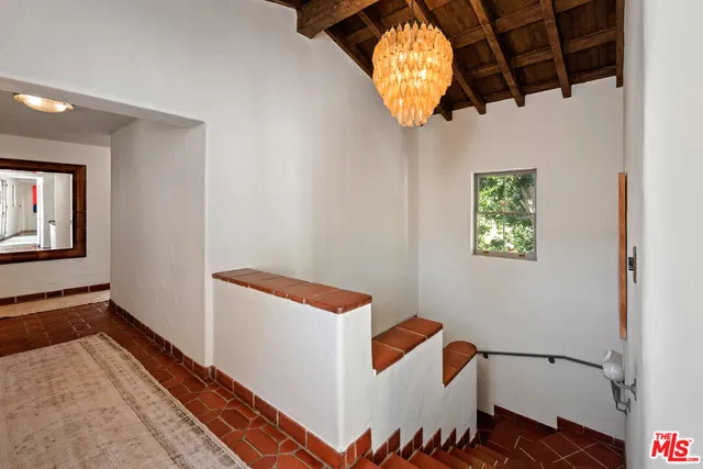 a view of a hallway with wooden floor and a bathroom