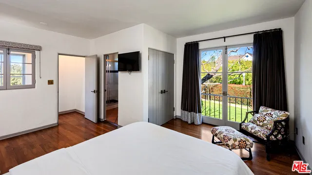 a bedroom with a bed and a large window