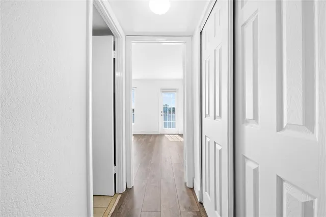a view of a hallway with wooden floor