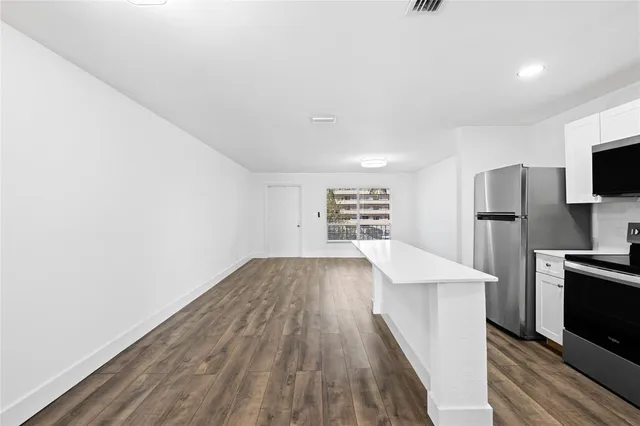 a view of kitchen with refrigerator stove and wooden cabinets