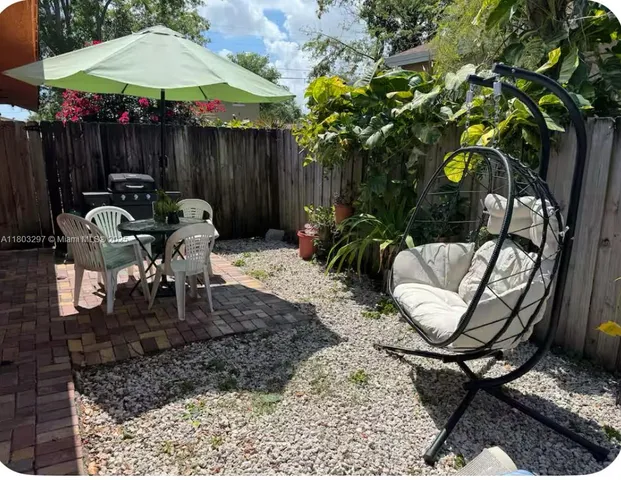 a backyard of a house with barbeque oven table and chairs