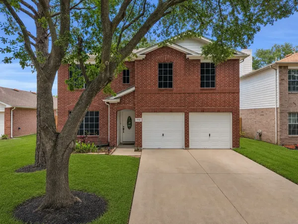 a front view of a house with a yard and trees