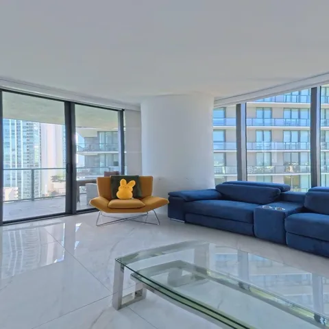 a large white kitchen with kitchen island a sink stainless steel appliances and cabinets