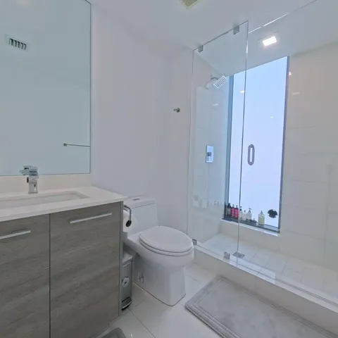 a large bedroom with a bed kitchen view and a window