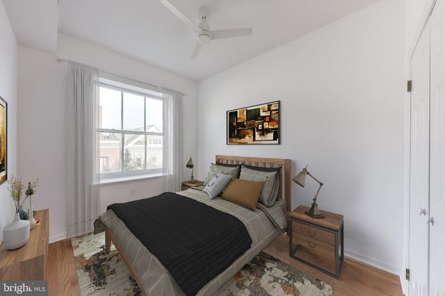 a bedroom with a bed a painting on the wall and a window
