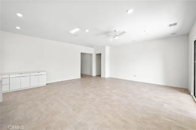 an empty room with an entryway and fan