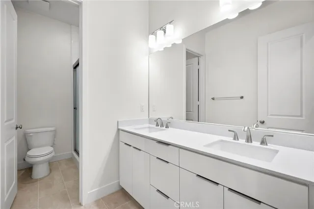 a bathroom with a sink a toilet and a large mirror