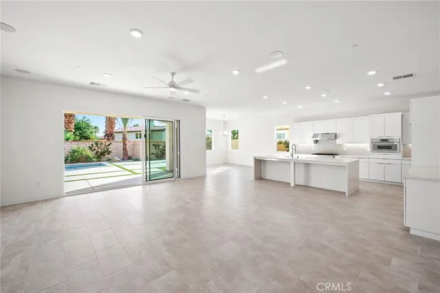 a view of a living room kitchen with white cabinets